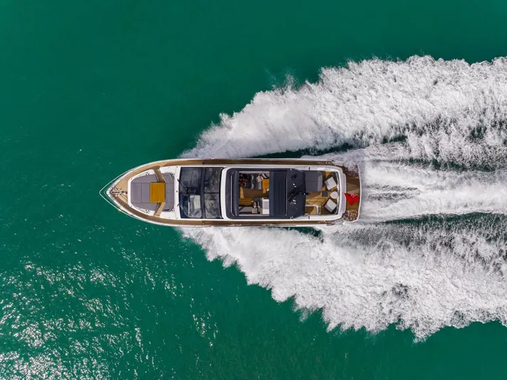 Yacht Photos Pics 2023 Pearl 72 Motor Yacht cruising on turquoise water, aerial view.