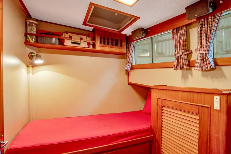 30 West Yacht Photos Pics Cozy cabin interior of 1991 Grand Banks 49 Classic with red bedding and wooden accents.
