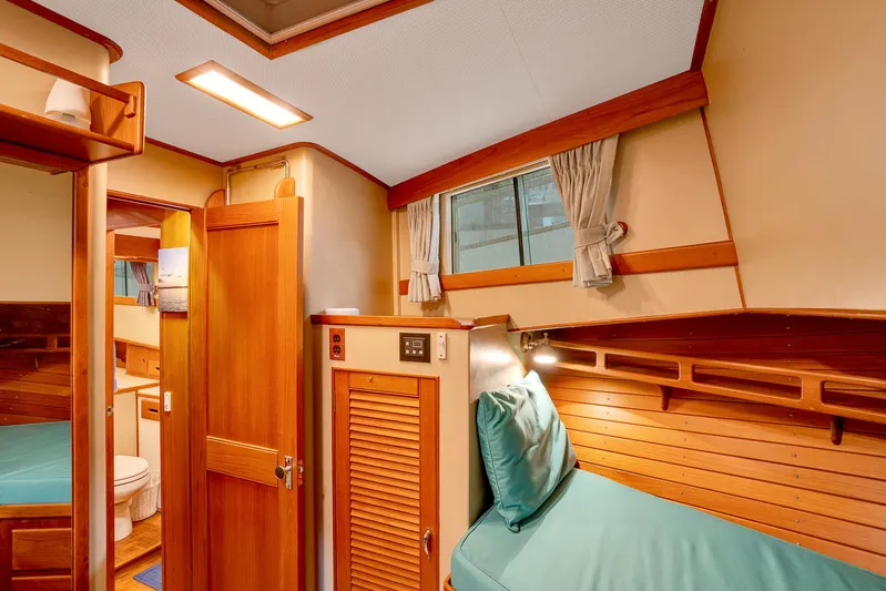 30 West Yacht Photos Pics Interior of 1991 Grand Banks 49 Classic yacht with wooden finishes and cozy sleeping area.