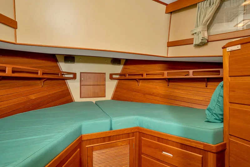 30 West Yacht Photos Pics 1991 Grand Banks 49 Classic cabin with teal bedding and wooden interior.