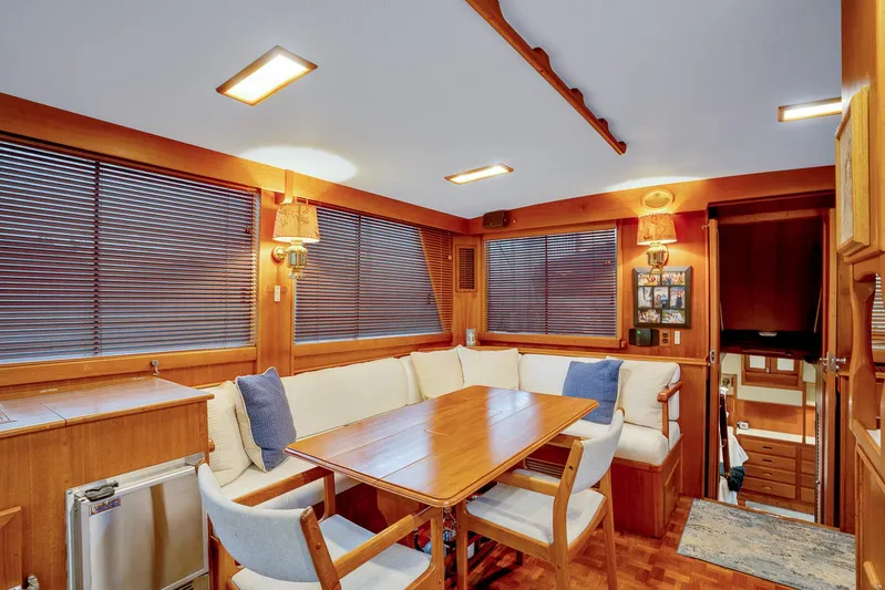 30 West Yacht Photos Pics Interior of 1991 Grand Banks 49 Classic yacht with cozy dining area and wooden furnishings.