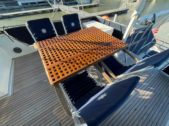 30 West Yacht Photos Pics Deck of 1991 Grand Banks 49 Classic with wooden table and navy chairs.
