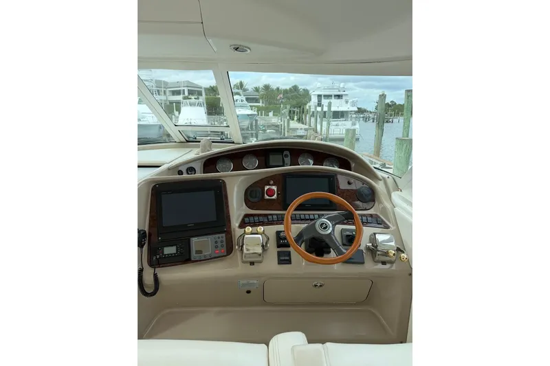  Yacht Photos Pics 2004 Sea Ray 480 Sedan Bridge helm with navigation equipment and wooden steering wheel.