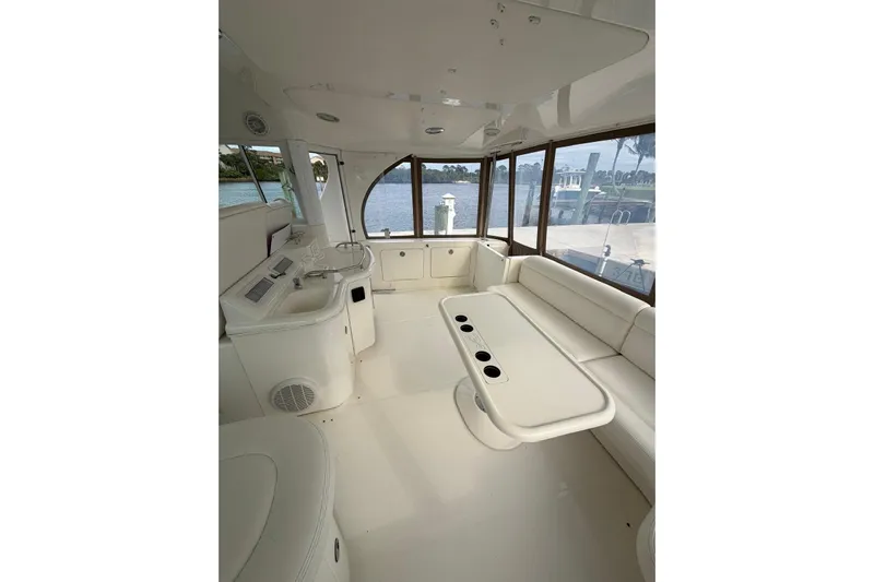  Yacht Photos Pics 2004 Sea Ray 480 Sedan Bridge interior with white seating and table, overlooking marina.