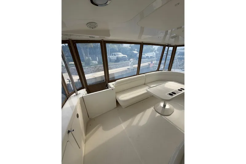  Yacht Photos Pics 2004 Sea Ray 480 Sedan Bridge interior with white seating and table, dockside view.