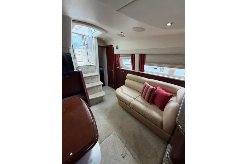  Yacht Photos Pics Luxurious interior of 2004 Sea Ray 480 Sedan Bridge with beige leather sofa and red accents.