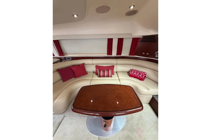  Yacht Photos Pics Luxurious interior of 2004 Sea Ray 480 Sedan Bridge with cream leather seating and red accents.