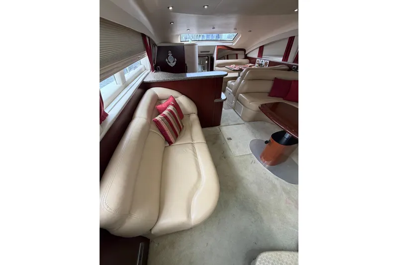  Yacht Photos Pics Luxurious interior of 2004 Sea Ray 480 Sedan Bridge with beige leather seating and red accents.