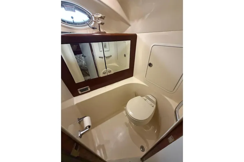  Yacht Photos Pics Bathroom interior of 2004 Sea Ray 480 Sedan Bridge yacht, featuring toilet and mirror.