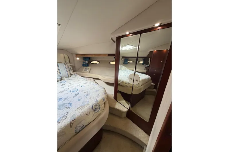  Yacht Photos Pics Luxurious 2004 Sea Ray 480 Sedan Bridge bedroom with mirrored closet and elegant bedding.