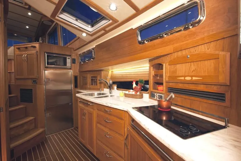 Vertical Yacht Photos Pics Luxurious 2017 Sabre 48 Salon Express yacht kitchen with wood cabinetry and modern appliances.