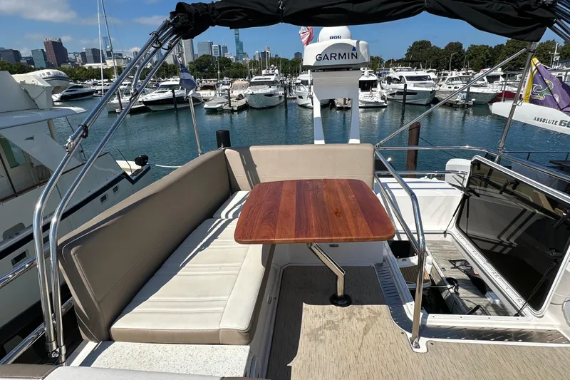  Yacht Photos Pics 2019 Regal 42 Fly yacht interior with seating and wooden table, docked at marina.