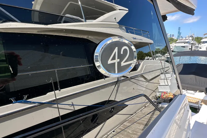  Yacht Photos Pics 2019 Regal 42 Fly yacht docked at marina, reflecting nearby boats and city skyline.