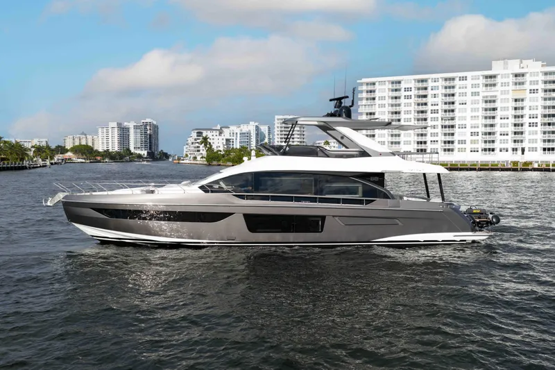 Next Play Yacht Photos Pics 2024 Azimut Fly 68 yacht cruising near modern waterfront buildings.