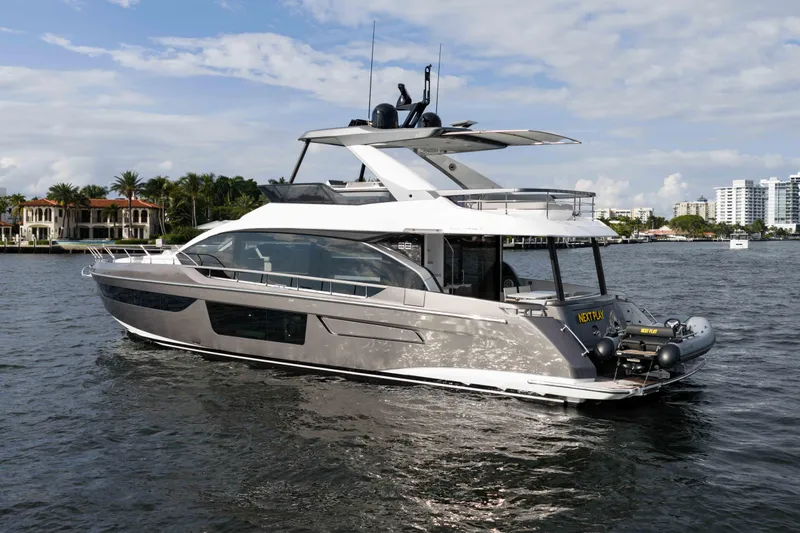 Next Play Yacht Photos Pics 2024 Azimut Fly 68 yacht cruising on a sunny day near luxury waterfront homes.