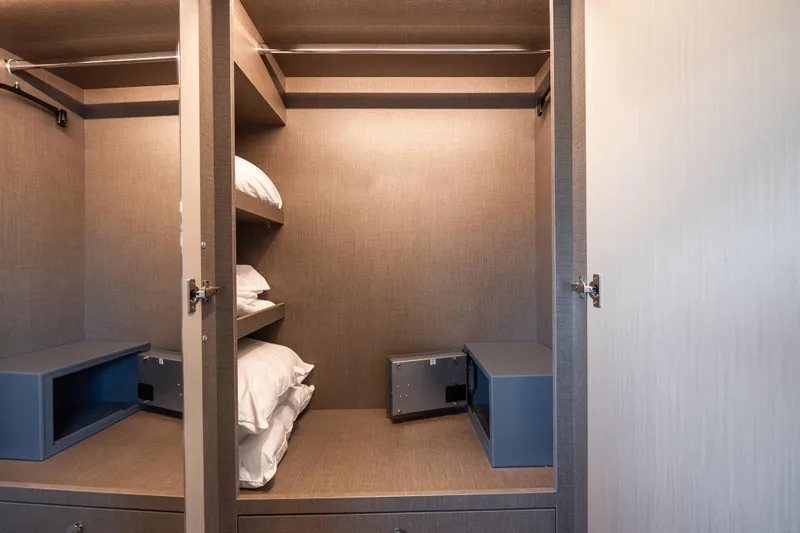 Next Play Yacht Photos Pics Luxurious closet interior on 2024 Azimut Fly 68 yacht, featuring shelves and safes.