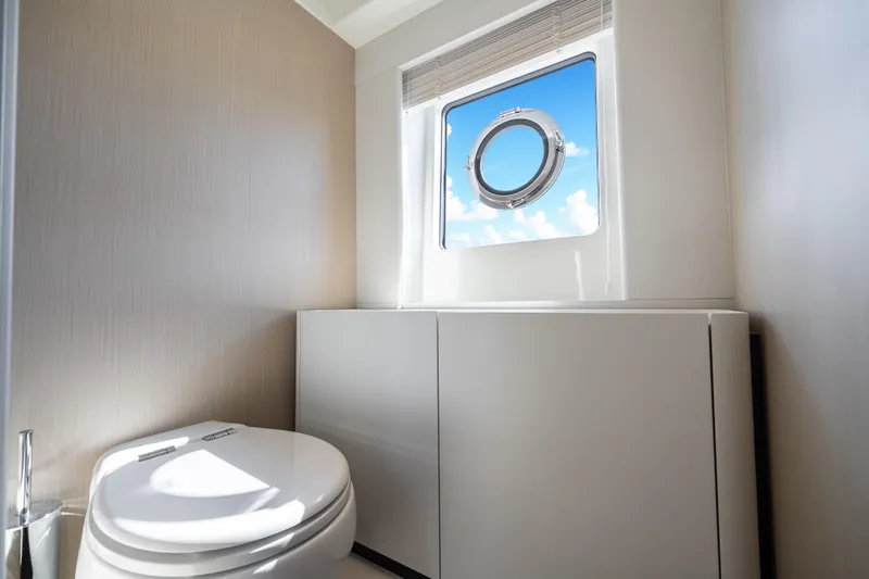 Next Play Yacht Photos Pics Luxurious bathroom interior of 2024 Azimut Fly 68 yacht with porthole view.