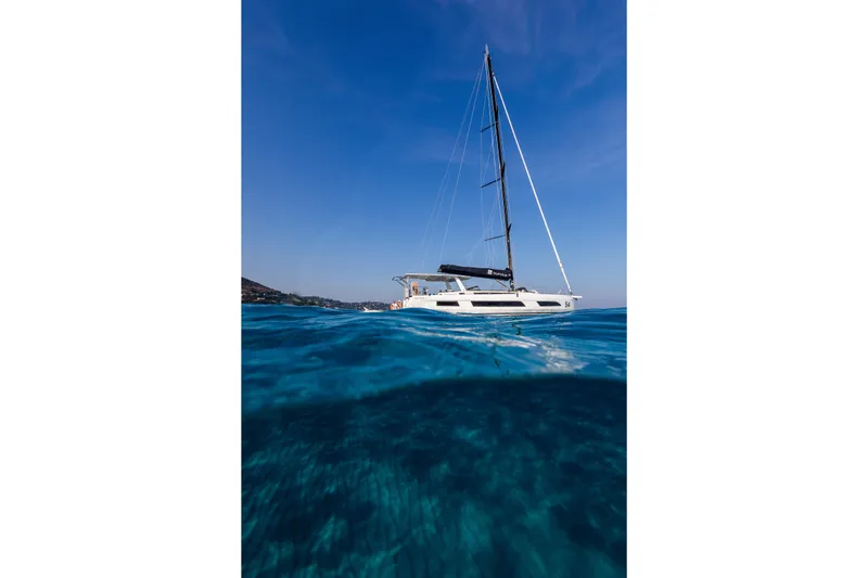 Yacht Photos Pics Sailing yacht Dufour 54, 2025 model, gliding on clear blue ocean under sunny sky.