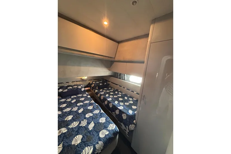  Yacht Photos Pics Interior cabin of 1992 Mochi Craft 46 yacht with twin beds and nautical-themed bedding.