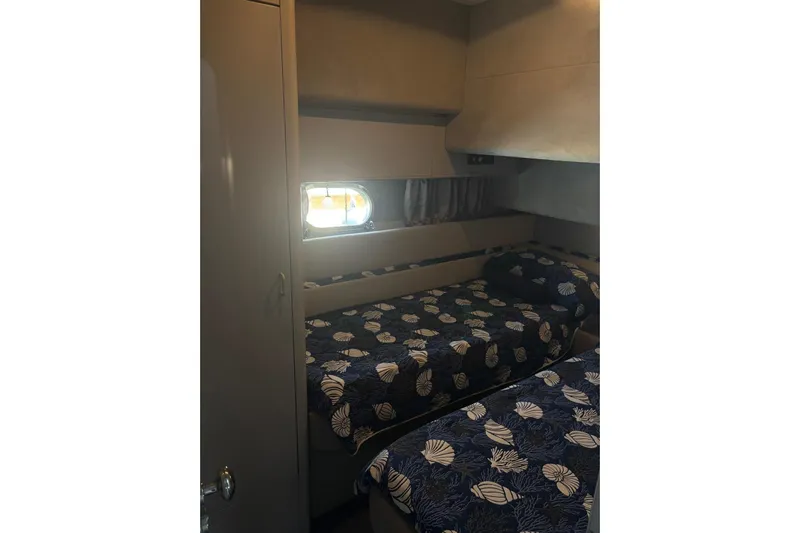  Yacht Photos Pics Cozy cabin interior of 1992 Mochi Craft 46 yacht with twin beds and nautical-themed bedding.