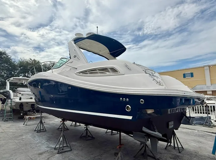  Yacht Photos Pics 2011 Sea Ray 350 Sundancer yacht on stands, blue and white exterior, under a cloudy sky.