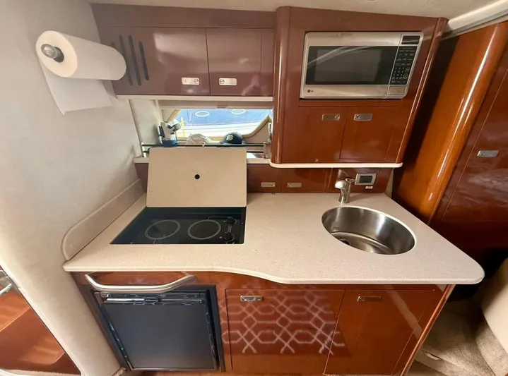  Yacht Photos Pics 2011 Sea Ray 350 Sundancer kitchen with stove, sink, microwave, and storage cabinets.