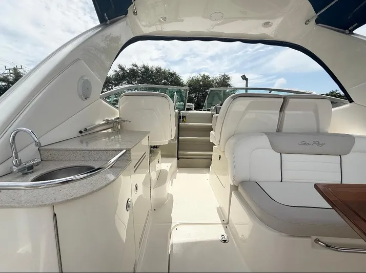  Yacht Photos Pics 2011 Sea Ray 350 Sundancer interior with seating, kitchenette, and stairs under a sunny sky.