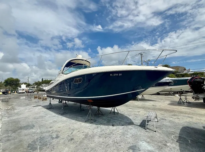  Yacht Photos Pics 2011 Sea Ray 350 Sundancer boat on dry dock under a partly cloudy sky.