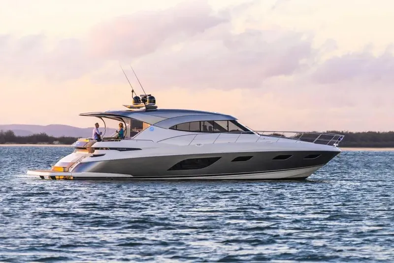  Yacht Photos Pics 2020 Riviera 6000 Motor Yacht cruising on calm waters at sunset.