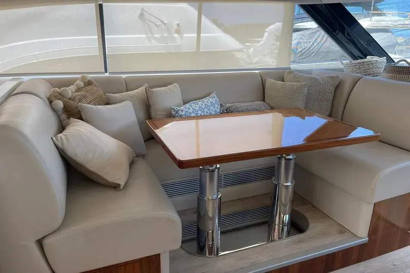  Yacht Photos Pics Luxurious seating area on 2020 Riviera 6000 Motor Yacht with plush cushions and wooden table.