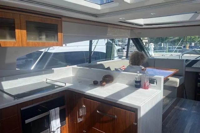  Yacht Photos Pics Luxurious interior of 2020 Riviera 6000 Sport Yacht Platinum Edition with modern kitchen and seating area.