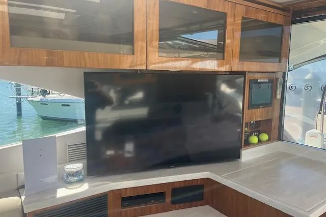  Yacht Photos Pics Interior of 2020 Riviera 6000 Sport Yacht Platinum Edition with TV and wooden cabinetry.
