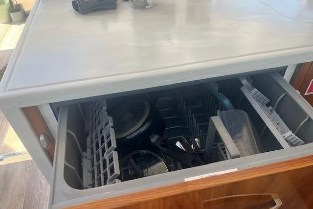  Yacht Photos Pics Open dishwasher drawer on 2020 Riviera 6000 Sport Yacht Platinum Edition, showcasing interior racks.