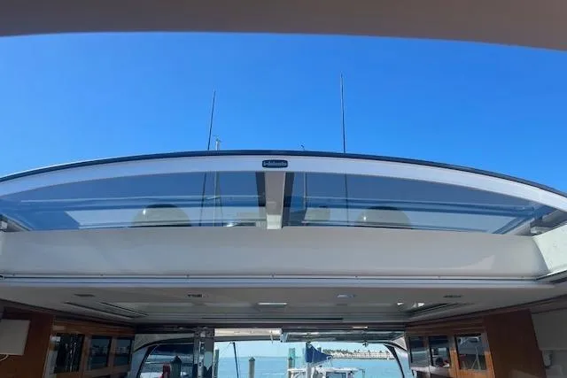  Yacht Photos Pics 2020 Riviera 6000 Sport Yacht Platinum Edition with open sunroof, showcasing clear blue sky.
