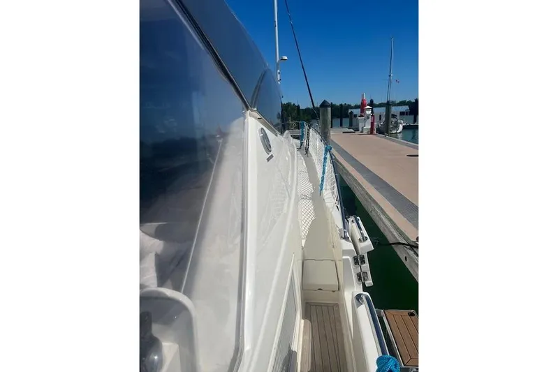  Yacht Photos Pics 2020 Riviera 6000 Sport Yacht Platinum Edition docked at marina under clear blue sky.