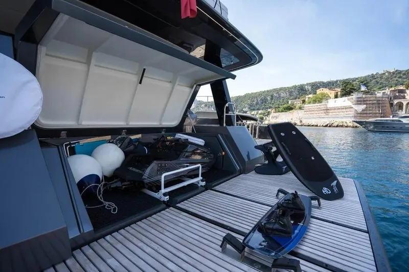  Yacht Photos Pics 2024 Sunreef 60 Power Eco yacht with open storage, water sports gear, docked by scenic coastline.