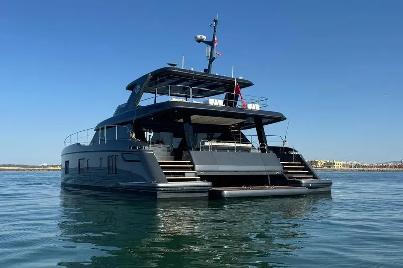  Yacht Photos Pics 2024 Sunreef 60 Power Eco yacht on calm water, showcasing sleek design and luxury features.