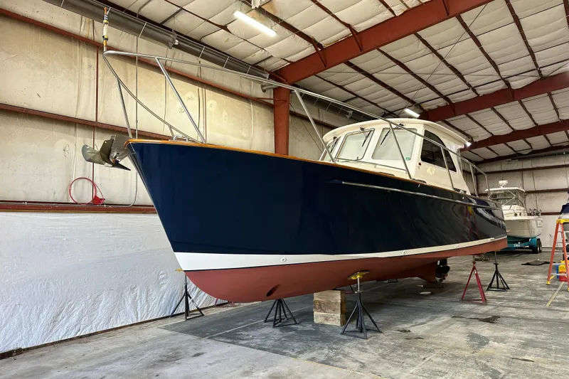 Picnic Boat Yacht Photos Pics 2003 Legacy Yachts 34 Express in a boatyard, elevated on stands.