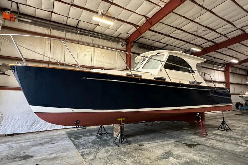 Picnic Boat Yacht Photos Pics 2003 Legacy Yachts 34 Express in a warehouse, elevated on stands.