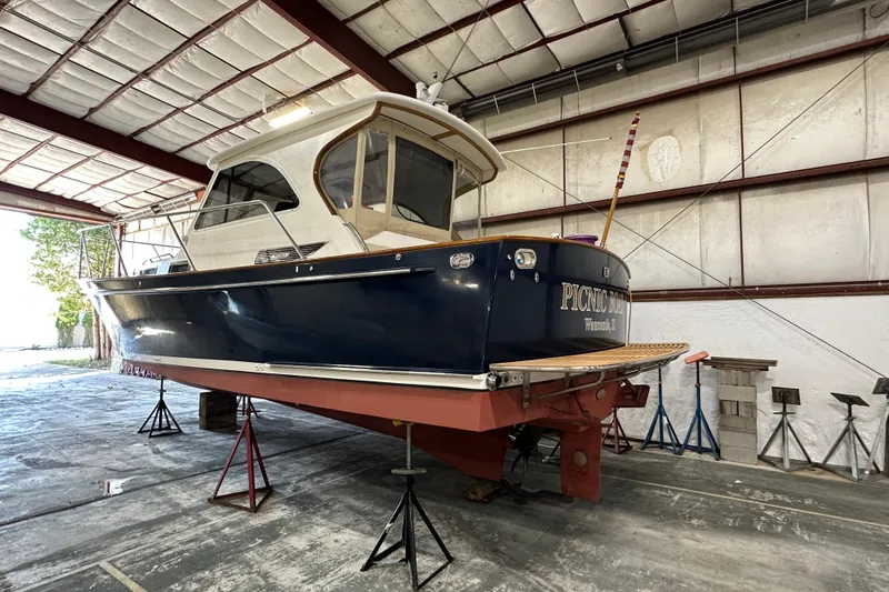 Picnic Boat Yacht Photos Pics 2003 Legacy Yachts 34 Express in storage, elevated on stands, inside a spacious warehouse.