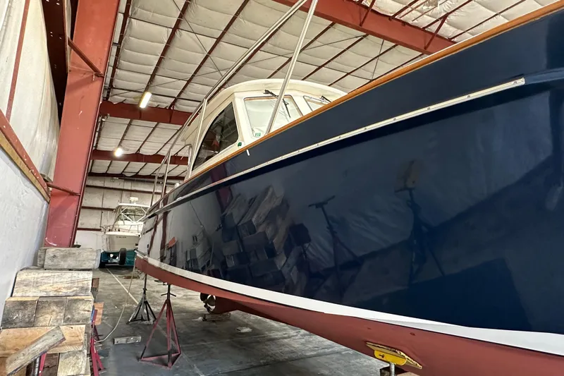 Picnic Boat Yacht Photos Pics 2003 Legacy Yachts 34 Express in storage, showcasing sleek blue hull design.