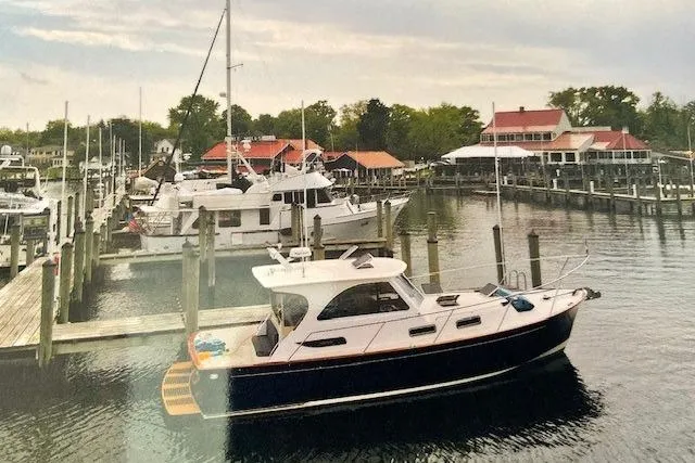 Picnic Boat Yacht Photos Pics 2003 Legacy Yachts 34 Express docked in a scenic marina with surrounding boats.