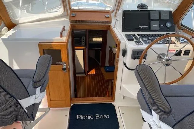 Picnic Boat Yacht Photos Pics 2003 Legacy Yachts 34 Express cockpit with helm, seating, and cabin entrance.