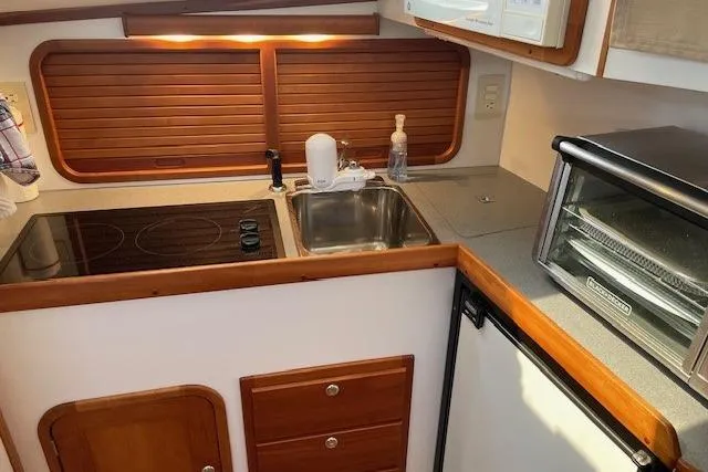 Picnic Boat Yacht Photos Pics Compact kitchen in 2003 Legacy Yachts 34 Express with stove, sink, and toaster oven.