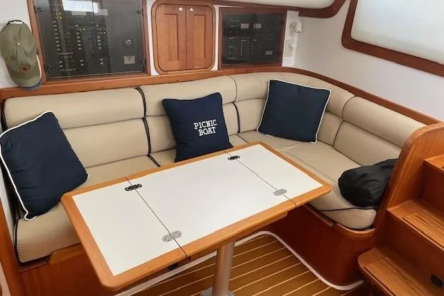 Picnic Boat Yacht Photos Pics 2003 Legacy Yachts 34 Express interior with beige seating, table, and nautical-themed cushions.