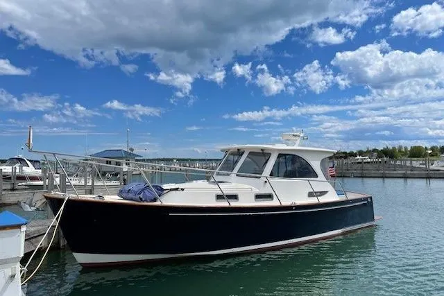 Picnic Boat Yacht Photos Pics 2003 Legacy Yachts 34 Express docked under a blue sky with clouds.