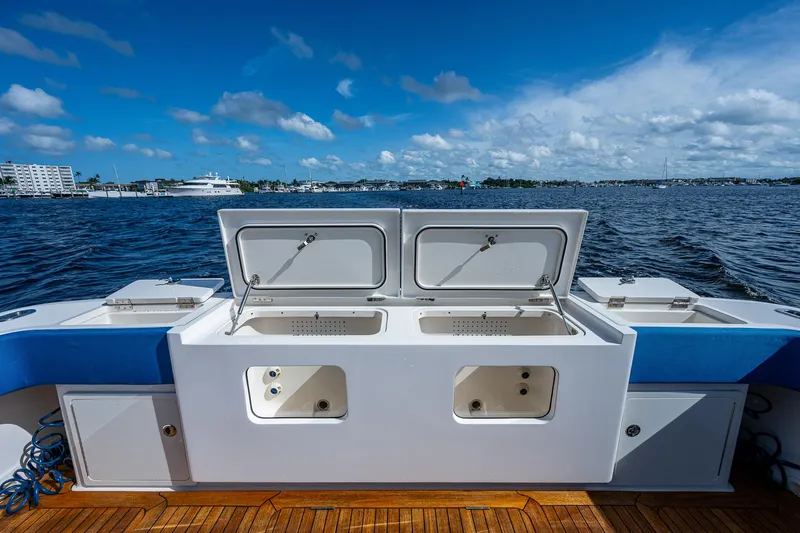 Mother Mary Yacht Photos Pics 2021 Gulf Crosser 52 boat with open storage compartments on deck, docked by the water.