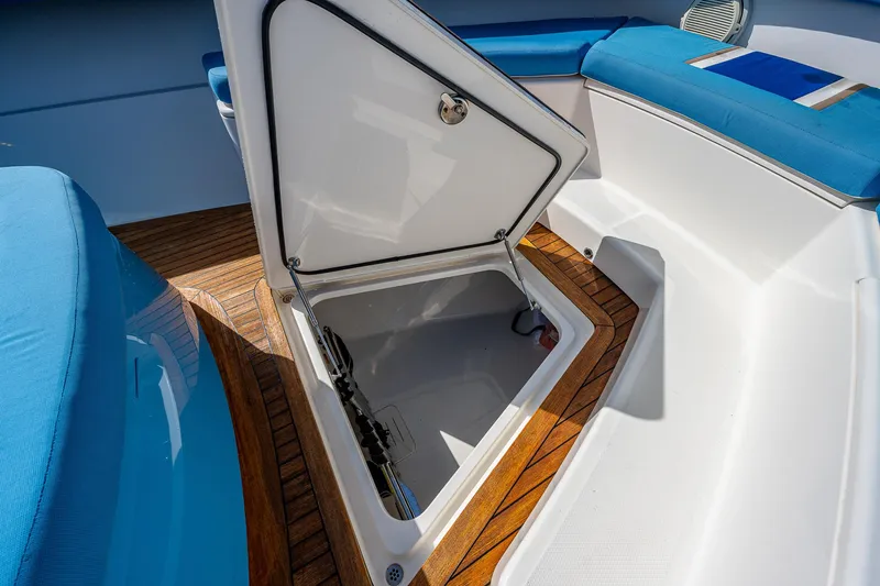 Mother Mary Yacht Photos Pics Open storage compartment on 2021 Gulf Crosser 52 boat with teak flooring and blue seating.