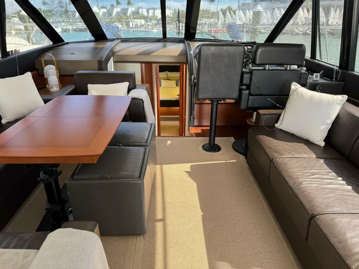 Blue Haven Yacht Photos Pics Luxurious interior of 2014 Prestige 620S yacht with leather seating and wooden table.