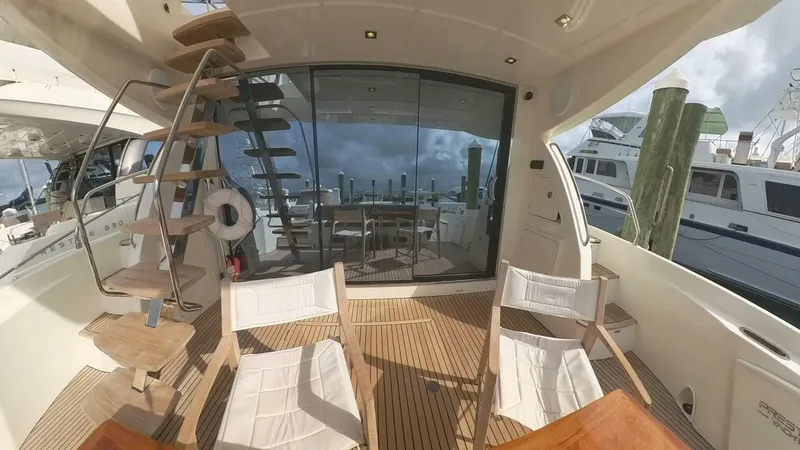 Blue Haven Yacht Photos Pics Prestige 620S 2014 yacht deck with seating and spiral staircase, docked at marina.